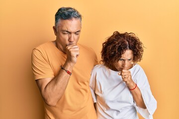 Sticker - Beautiful middle age couple together wearing casual clothes feeling unwell and coughing as symptom for cold or bronchitis. health care concept.