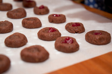 Wall Mural - Chocolate Dough And Cherry Jam On A Sheet Of Baking Paper Intended To Be Baked To Become Cookies