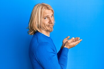 Sticker - Caucasian young man with long hair presenting with open palms, holding something skeptic and nervous, frowning upset because of problem. negative person.