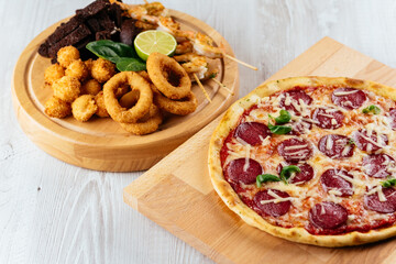 Italian pizza and beer snacks on a wooden Board and light backgr