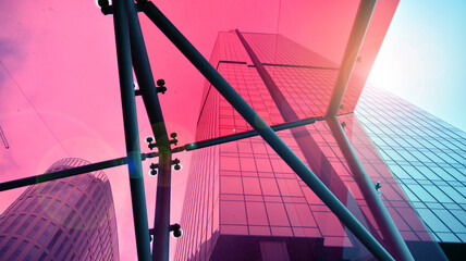 Bottom view of modern office buildings in the business district. Skyscraper glass facades on a bright sunny day with sunbeams in the blue sky.