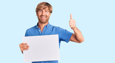 Poster - Handsome caucasian man with beard holding sale poster smiling happy and positive, thumb up doing excellent and approval sign