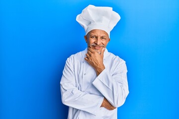 Poster - Middle age grey-haired man wearing professional cook uniform and hat looking confident at the camera smiling with crossed arms and hand raised on chin. thinking positive.