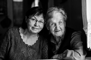 Poster - Portrait of middle-aged woman with his old mother. Black and white photo.