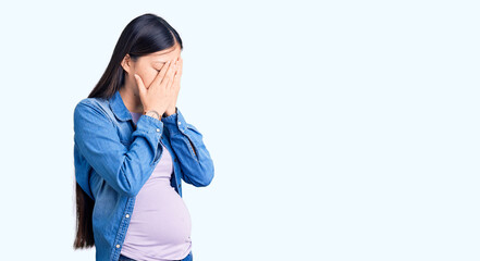 Sticker - Young beautiful chinese woman pregnant expecting baby with sad expression covering face with hands while crying. depression concept.