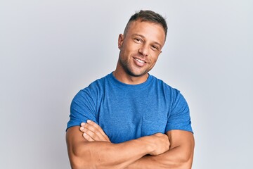 Handsome muscle man wearing casual clothes happy face smiling with crossed arms looking at the camera. positive person.