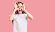 Cute hispanic child girl wearing casual white tshirt doing ok gesture like binoculars sticking tongue out, eyes looking through fingers. crazy expression.