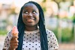 © Krakenimages.com - Young african american woman smiling happy eating ice cream at the city.