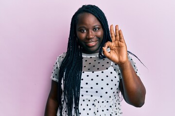 Poster - Young black woman with braids wearing casual clothes smiling positive doing ok sign with hand and fingers. successful expression.