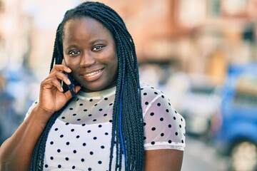 Young african american woman smiling happy talking on the smartphone at the city.