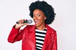 © Krakenimages.com - Young african american woman singing song using microphone looking positive and happy standing and smiling with a confident smile showing teeth