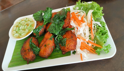 Fish cake, fried spicy fish balls top with crispy basil and sweet sauce.