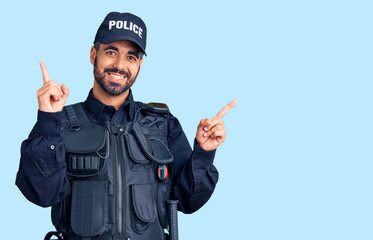 Poster - Young hispanic man wearing police uniform smiling confident pointing with fingers to different directions. copy space for advertisement