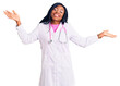 © Krakenimages.com - Young african american woman wearing doctor stethoscope clueless and confused expression with arms and hands raised. doubt concept.