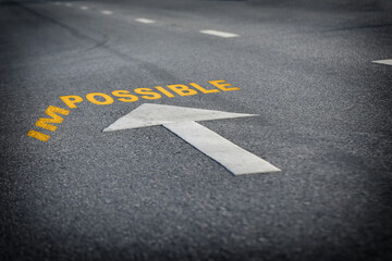 Impossible word without im with arrow on black asphalt road surface, business challenge concept and overcome success idea