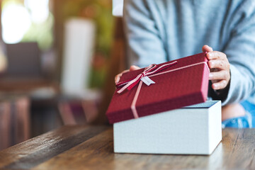 Wall Mural - Closeup image of a woman opening a gift box