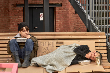 two beggar boys in the cold weather outdoors, child abuse, social poverty problems