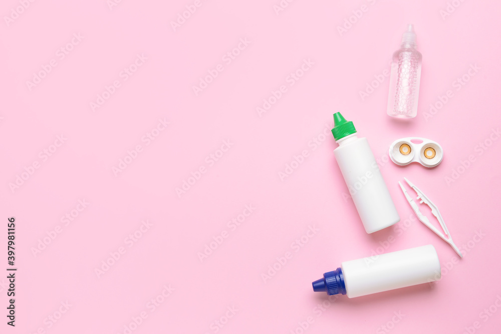 Container with contact lenses, solutions and tweezers on color background