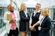 © Roman - group of african and caucasian business women happily talking about something,wearing formal wear, share opinions, discussing, during conference