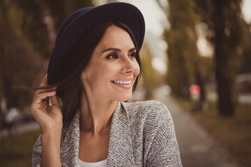 Sticker - Photo portrait of smiling woman wearing hat walking in city park windy weather in fall