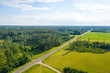 aerial view on rural countryside road through forest, agricultural lands and villages