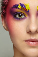 Close-up female half face portrait with unusual face art make-up and freckles.