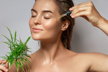 Wall Mural - cbd cosmetics concept. beautiful woman with a cannabis leaf