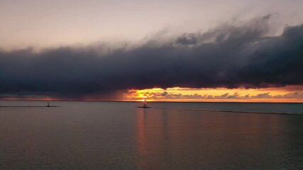 Wall Mural - beautiful panning out sunset aerial of the white colored ludington breakwater lighthouse with pink a