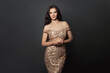 © millaf (Nemchinova) - Luxurious brunette model woman in golden evening gown posing on black background