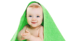 Portrait Close Up Of Sweet Baby Under Green Towel Over A White Background