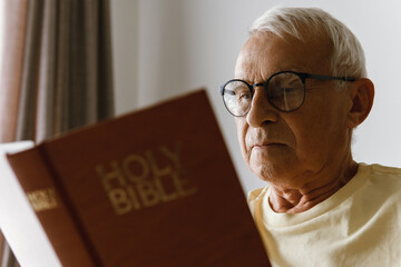 Elderly man reading holy bible