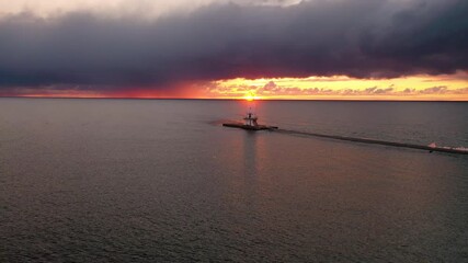 Wall Mural - beautiful panning aerial of the ludington breakwater lighthouse with the sun reflecting on the water