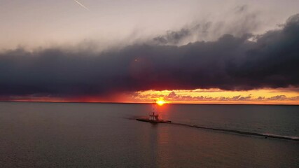 Wall Mural - beautiful panning aerial of the ludington breakwater lighthouse with the sun reflecting on the water