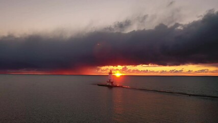 Wall Mural - beautiful panning aerial of the ludington breakwater lighthouse with the sun reflecting on the water