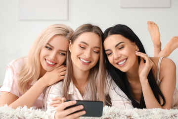 Wall Mural - Beautiful young women taking selfie at slumber party