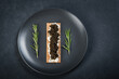 Black caviar of sturgeon in the biscuits with cream cheese. Spoon with caviar. Round blue plate. Dark background 