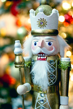 Christmas Nutcracker With Bokeh Christmas Tree Background. Golden And White In Color. Close Up.