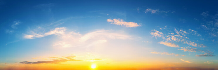 Wall Mural - Sky at sunset blue and orange light of the sun through the clouds in the sky