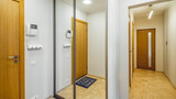 Fototapeta Tulipany - Contemporary interior of entrance hall in flat. Wooden doors. Wardrobe with mirror. Narrow hallway.
