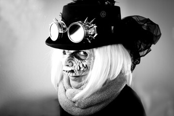 Woman with monster face and black hat wearing steampunk glasses