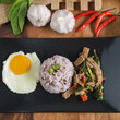 Stir-fried beef basil with fried egg and riceberry rice.