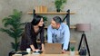 © viacheslav - Smiling man and woman employees working together in an office preparing presentation for meeting. Manager shows report to businesswoman on laptop computer