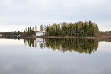 Wall Mural - Boathouse and trees on shore reflecting in still Kashwitna Lake, Alaska