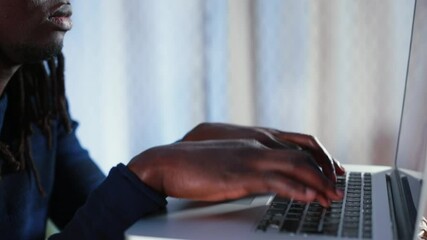 Poster - Focus of attention in the monitor. Black male freelancer typing text on laptop keyboard, preparing message to manager. Using the Internet in communication at a distance. Decision-making.