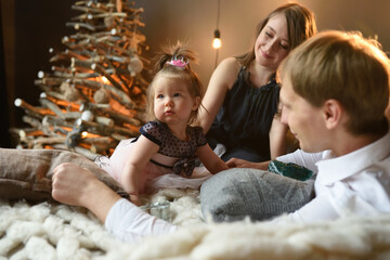 Wall Mural - Father mom and their little one year old daughter have fun together before christmas.