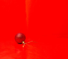 Red Shiny Ball Of Christmas Tree Decoration In A Red Background