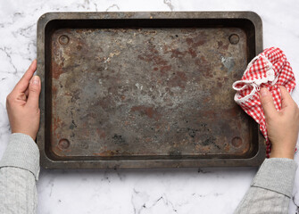 empty metal rectangular baking sheet on a white table, top view