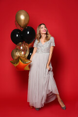 Poster - Happy woman with air balloons on red background. Christmas party