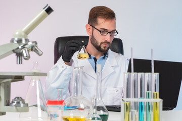 Poster - male laboratory technician at work. he is experimenting with reagents. career laboratory technician.