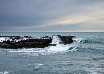 Sticker - Stormy sea and snowy cliff in evening